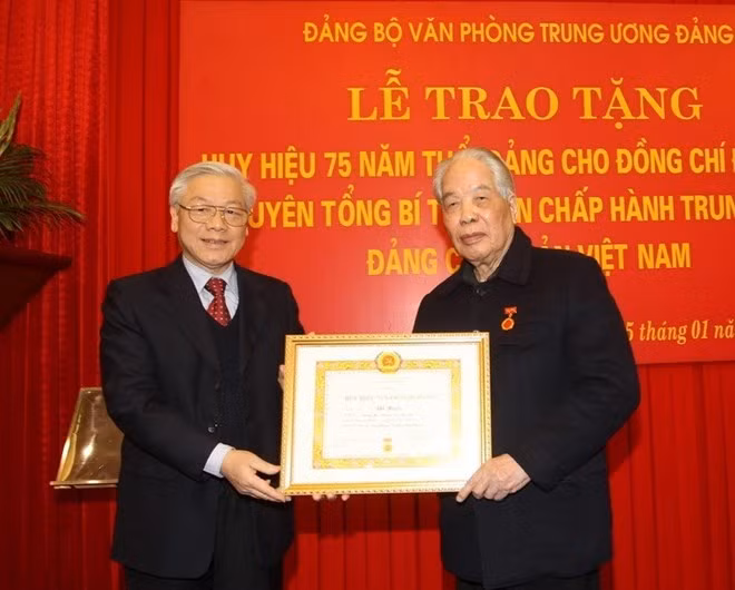 2014年1月越共中央总书记阮富仲向原越共中央总书记杜梅授予七十五年党龄纪念章。图自越通社