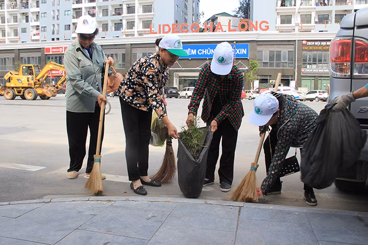 下龙市民在陈兴道街道上打扫，携手保护环境。