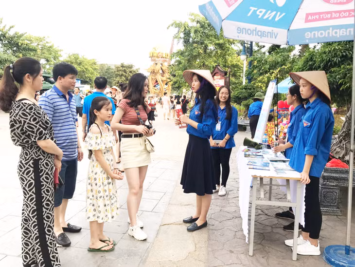 共青团广宁省各机关部团委旅游信息协助俱乐部向游客介绍太阳主题公园游乐场所。