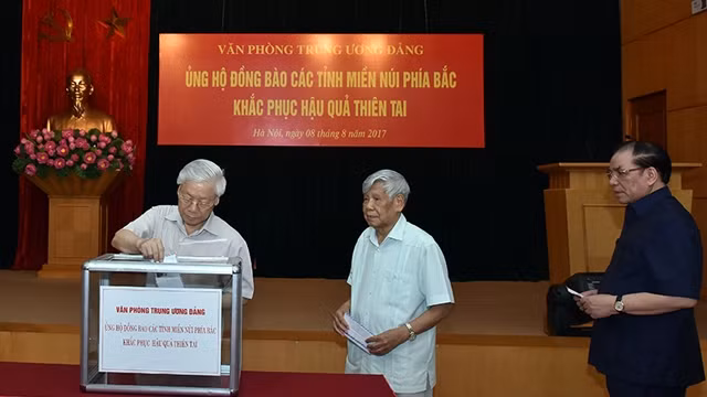 阮富仲总书记为灾民捐款。（图片来源：维灵 摄）