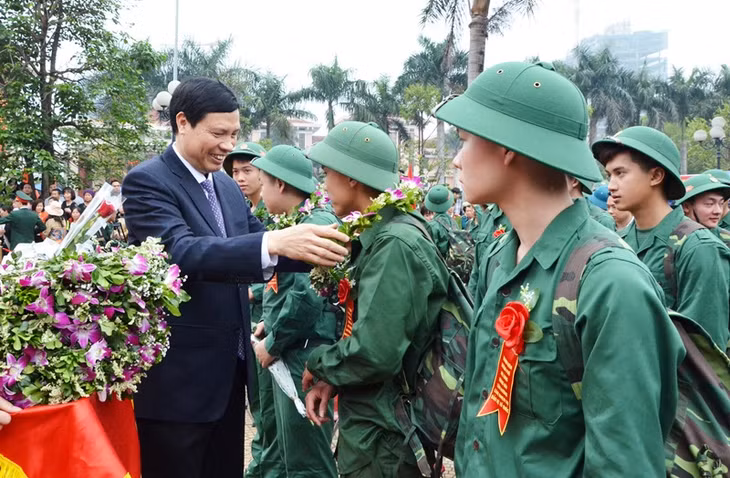 我省省委副书记、省军事义务委员会主席阮德龙向下龙市新兵们赠送鲜花。