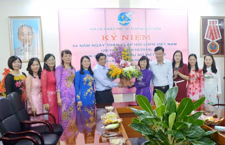 我省省委书记范明正向省妇联干部人员赠送鲜花表示祝福。