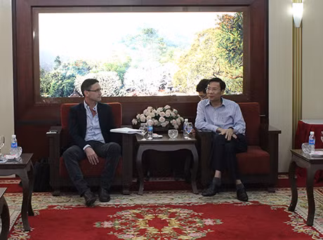 我省人民委员会主席阮文读与Jake Morse先生交谈。