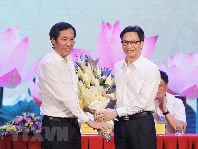 武德儋副总理（右）向越南新闻工作者协会主席顺友送花（图片来源：越通社）