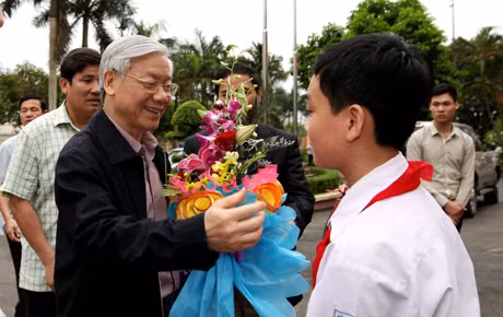 云屯县学生们向党中央总书记阮富仲赠送鲜花致以欢迎。