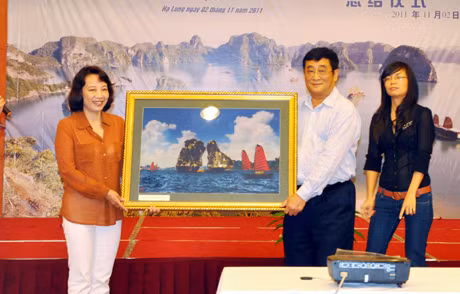 省人委会副主席武氏秋水向中国运德集团董事长亓竞生赠送下龙湾风景画。