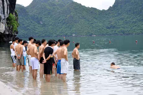 教练员介绍急救溺水者的游泳方法。