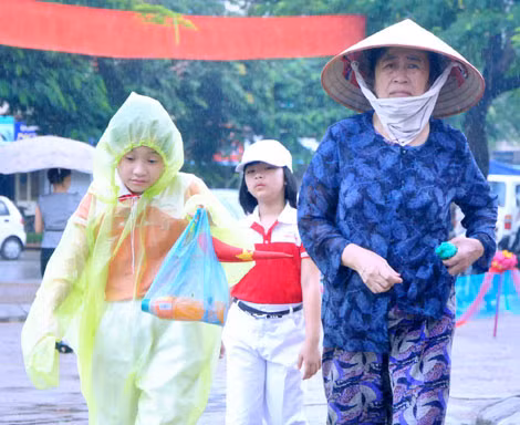 一位阿妈不管下大雨携带侄子上学。
