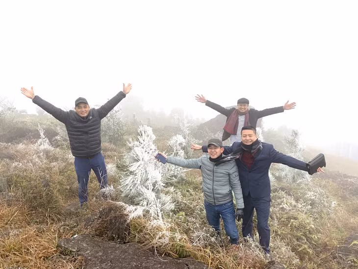 游客在海河县广德乡1337号地标观赏冰雪现象。