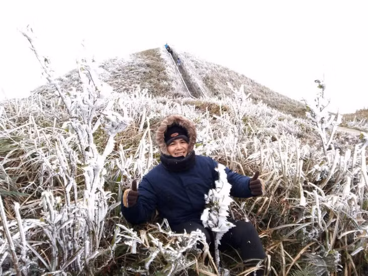 游客喜欢与冰雪美景拍照。