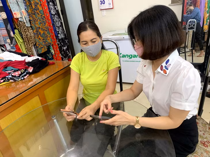 白藤坊妇女协会人员引导市民安装Bluezone应用程序。