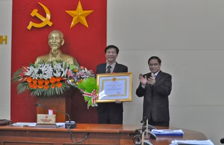 省委书记范明正向省人民委员会主席阮文读授予三等劳动勋章。