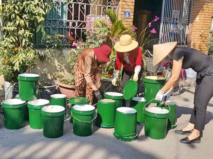 锦普市妇联会会员收集旧油漆桶制作环保垃圾桶。