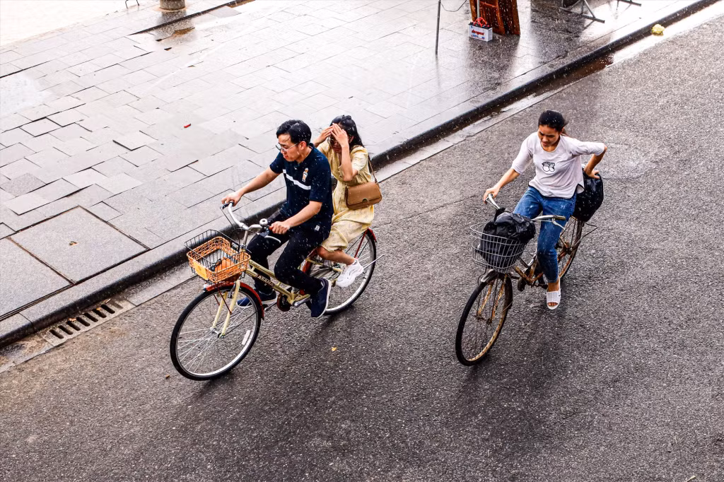 路上，骑自行车的人正匆忙“逃离”这突如其来的阵雨 Đạp xe “trốn” cơn mưa bất chợt