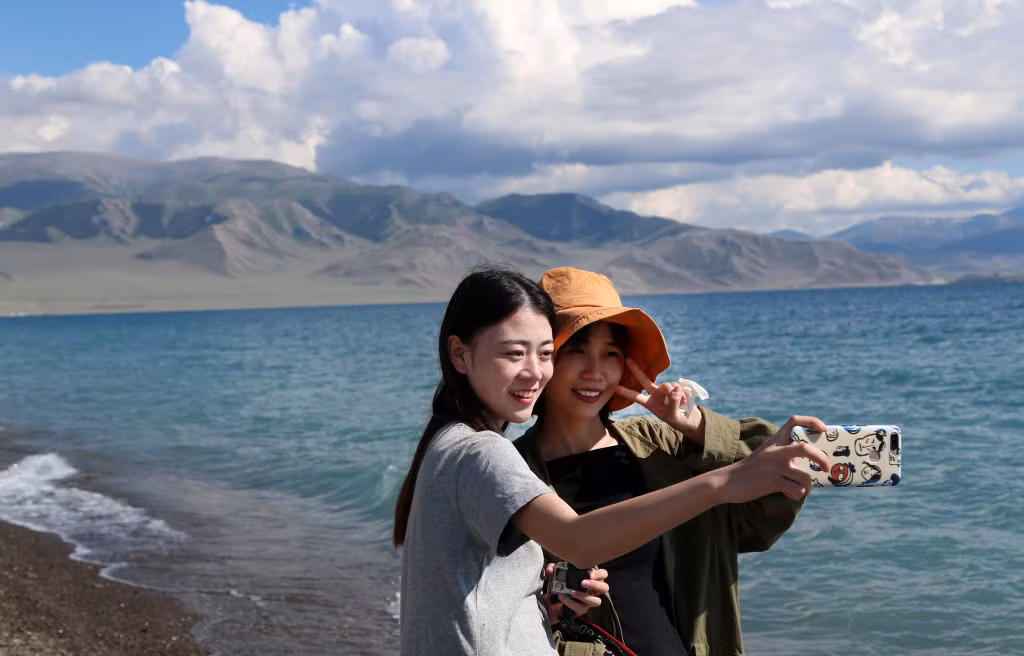 游客在新疆赛里木湖开心留影。 Du khách vui vẻ chụp ảnh lưu niệm tại hồ Sayram Tân Cương.