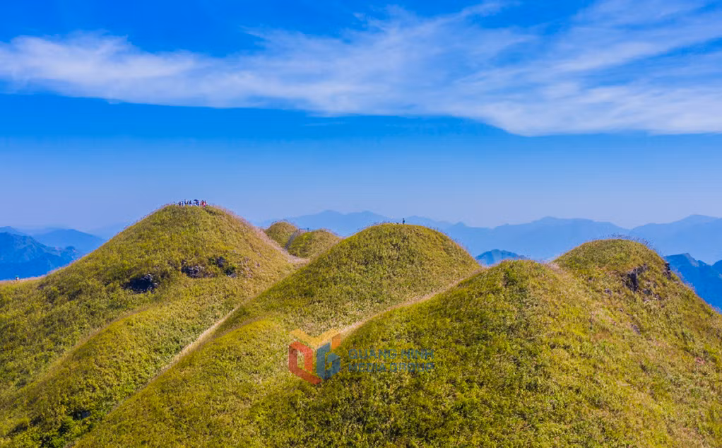蓝云下连绵起伏的草山。