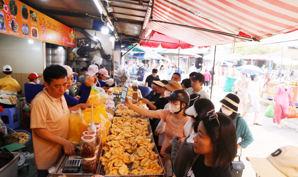 游客在1号下龙集市给亲朋好友购买墨鱼丸作为礼品。