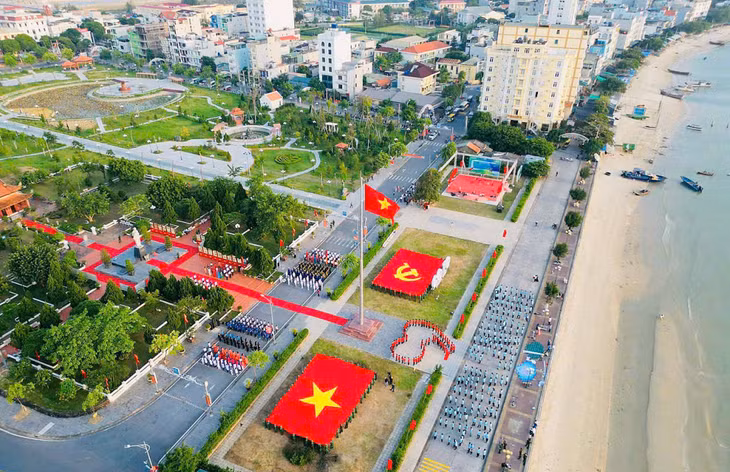 姑苏岛上胡志明主席纪念碑前的国旗在风中飘扬、营造浓浓节日氛围。