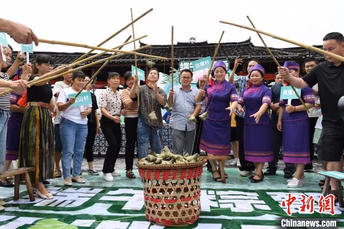 民众在参加钓粽子比赛。 Người dân đang tham gia cuộc thi câu bánh chưng.