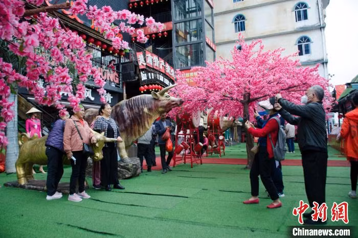 图为游客在东兴国门景区打卡，这里以销售越南特色商品为主，是游客到东兴购物的主要场所。 Hình ảnh du khách check-in tại Khu du lịch Quốc Môn, Đông Hưng, khu vực này chủ yếu bán các sản phẩm đặc sắc của Việt Nam, là địa điểm mua hàng chính của du khách khi tới Đông Hưng.