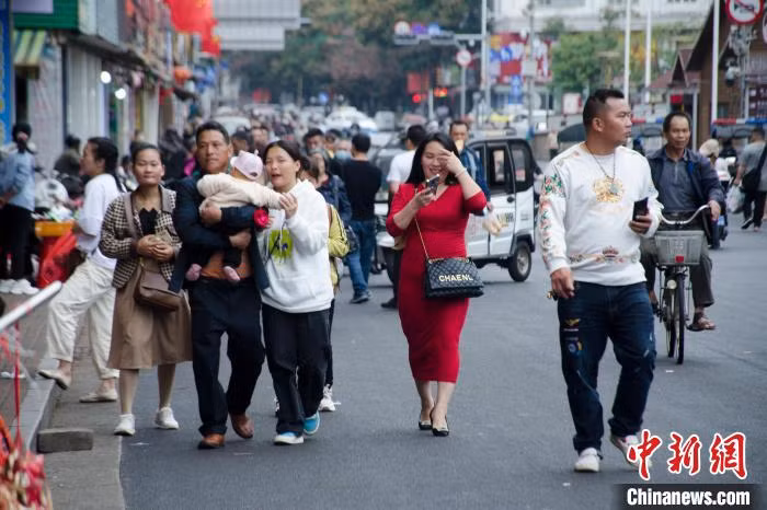 图为游客在东兴口岸附近的新华路逛街。 Hình ảnh du khách dạo phố trên đường Tân Hoa gần cửa khẩu Đông Hưng.