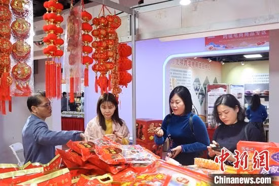 消费者现场采购年货。 Người tiêu dùng mua sắm hàng Tết tại chợ