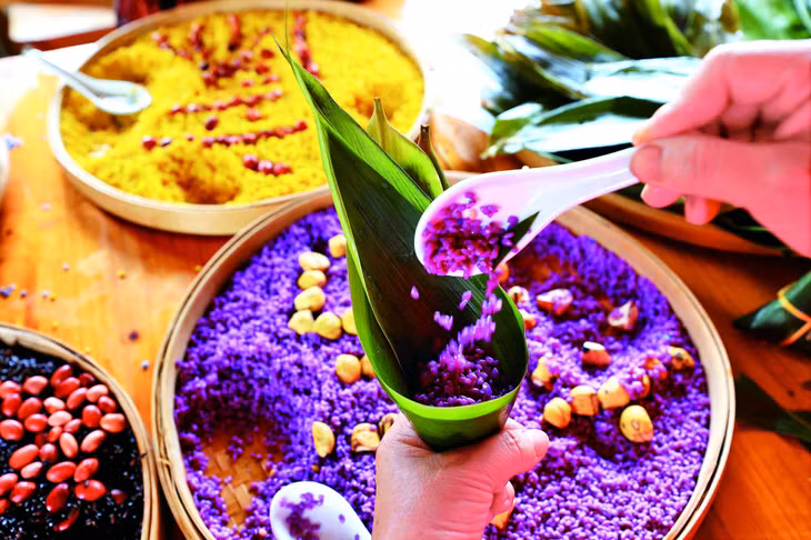 广西壮族群众制作五彩粽子迎端午。（图/新华社） Đồng bào dân tộc Choang Quảng Tây làm bánh chưng ngũ sắc đón tết Đoan Ngọ. (Ảnh/Tân Hoa Xã)