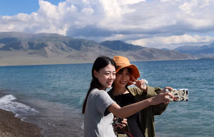 游客在新疆赛里木湖开心留影。 Du khách vui vẻ chụp ảnh lưu niệm tại hồ Sayram Tân Cương.