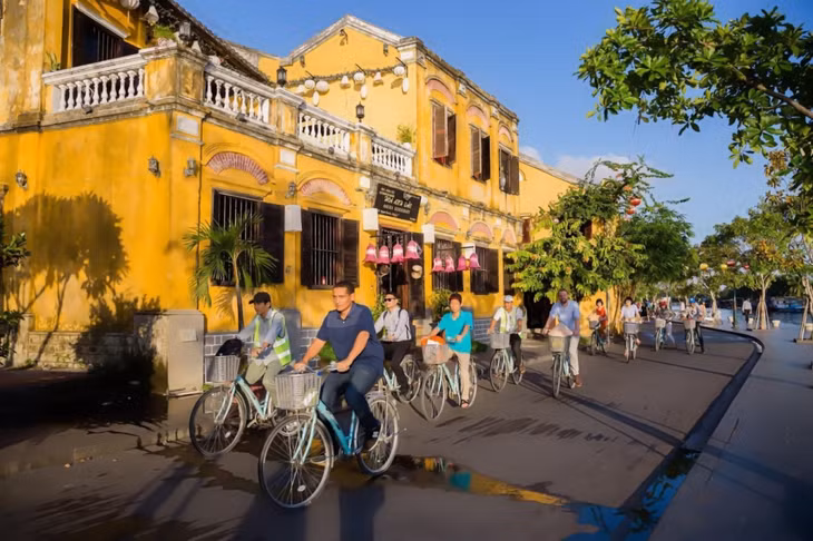 游客喜欢骑车在会安古街上闲逛 Du khách yêu thích đạp xe quanh phố cổ Hội An.