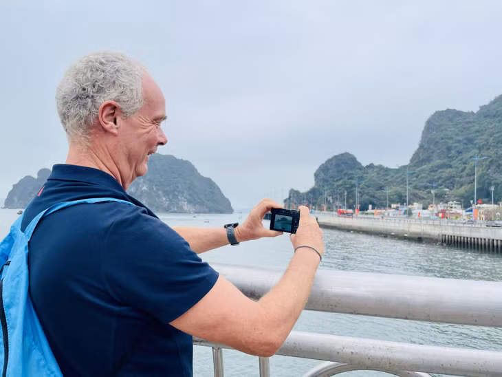 越南下龙号船队Han Van Roosmalands 和其他船队成员在参加下龙免费徒步游览中兴高采烈对下龙市的美景进行拍照。