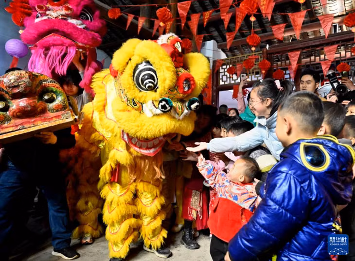 广西柳州市柳江区进德镇举行“上花灯”系列民俗闹元宵活动。这是舞狮艺人向小朋友派发礼物。黎寒池 摄 Thị trấn Tiến Đức, khu Liễu Giang, thành phố Liễu Châu, Quảng Tây tổ chức loạt hoạt động tết Nguyên Tiêu tập tục dân gian “Thượng Hoa Đăng”. Trong ảnh là nghệ nhân múa sư tử tặng quà tết cho các cháu nhỏ.