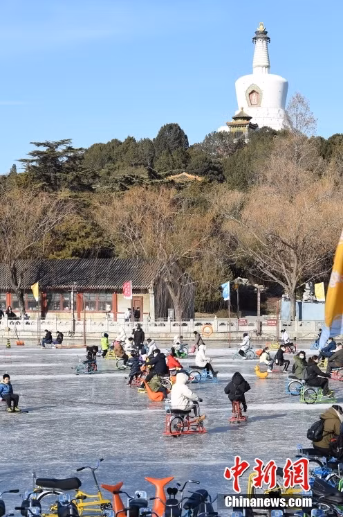 游客北海公园冰场体验冰雪项目。 Du khách trải nghiệm các hạng mục băng tuyết tại sân băng Công viên Bắc Hải.