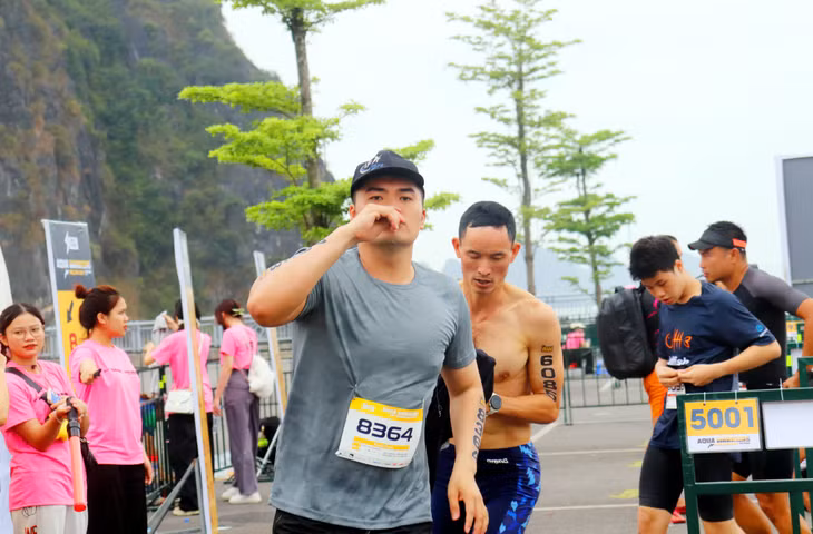 完成游泳比赛后，运动员们立即返回岸边继续跑步。