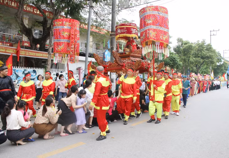 当抬陈王雕像的游行队经过时，人们从桥下排队穿过，祈求平安、吉祥。