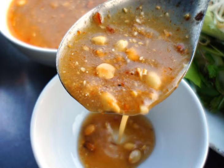 凉拌蘸料橙黄的颜色和清甜的口味非常诱人 Nước chấm gỏi hấp dẫn với màu vàng cam, vị ngọt thanh