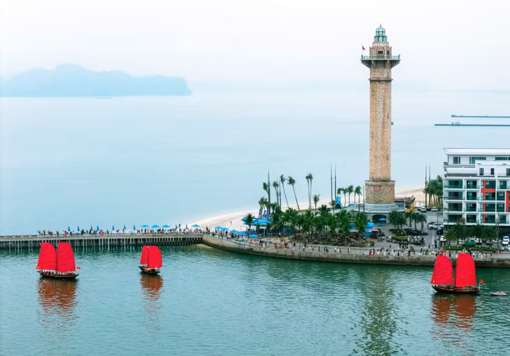 船只由木材打造并漆成棕色，两面红帆格外醒目，在下龙湾海面上形成了鲜明的色彩对比。 Thuyền được đóng bằng gỗ, sơn màu nâu, nổi bật với hai cánh buồm đỏ tạo nên sắc thái đối lập trên mặt biển vịnh Hạ Long.