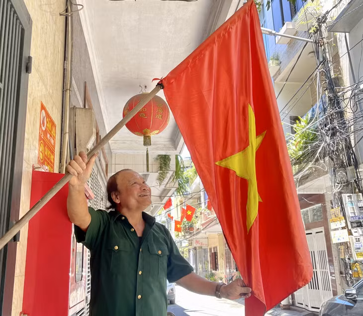 下龙市白腾坊居民在悬挂国旗时感到十分自豪和兴奋。