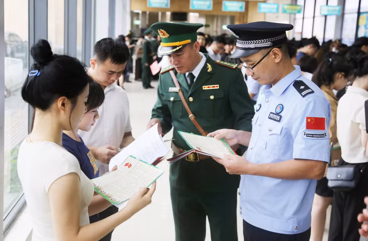 越南边防部队军官和中国国家移民管理局年轻干部向越中两国 边界地区居民宣传法律。
