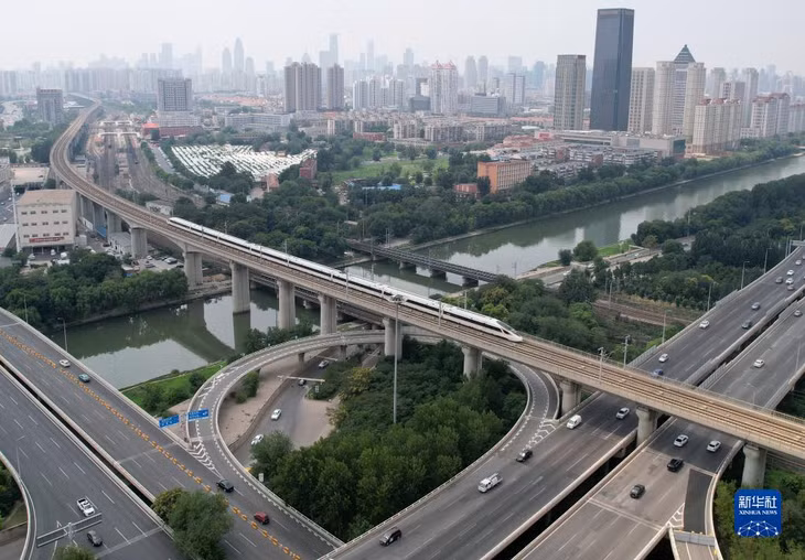 京津城际列车从天津城区穿行（7月20日摄，无人机照片） Chuyến tàu liên thành phố Bắc Kinh - Thiên Tân đi qua nội thành thành phố Thiên Tân (chụp ngày 20 tháng 7 bởi máy bay không người lái)