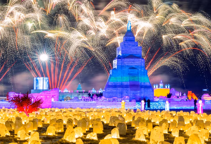 1月12日，第三届中国呼和浩特欢乐冰雪节开幕式现场，烟花与“丝路之光”主塔冰雕交相辉映。 Ngày 12/1/2024, hình ảnh ngọn tháp băng tỏa sáng trên nền pháo hoa trong Lễ khai mạc Lễ hội băng tuyết Hohhot Trung Quốc lần thứ 3. IC Photo