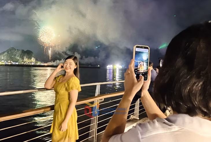 游客在烟花绽放的难忘时刻拍照。