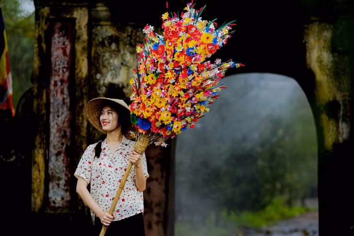 少女持纸花 图：黎庭黄 Hoa giấy khoe sắc Ảnh: Lê Đình Hoàng