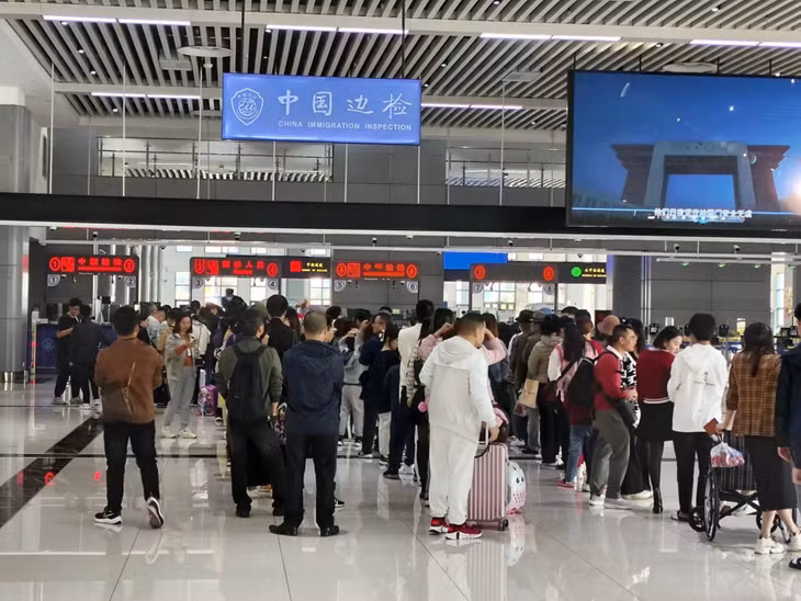 中国游客在北仑河二桥口岸办理通关手续。