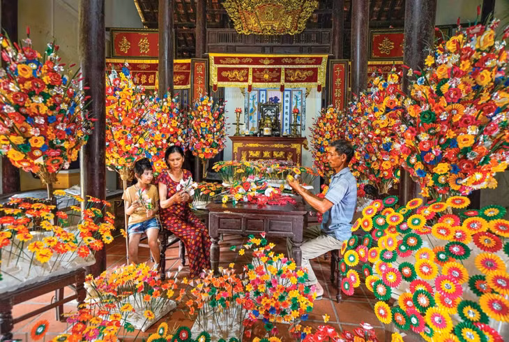 孩子在向大人学习纸花制作技艺 Con trẻ học nghề làm hoa giấy với người lớn