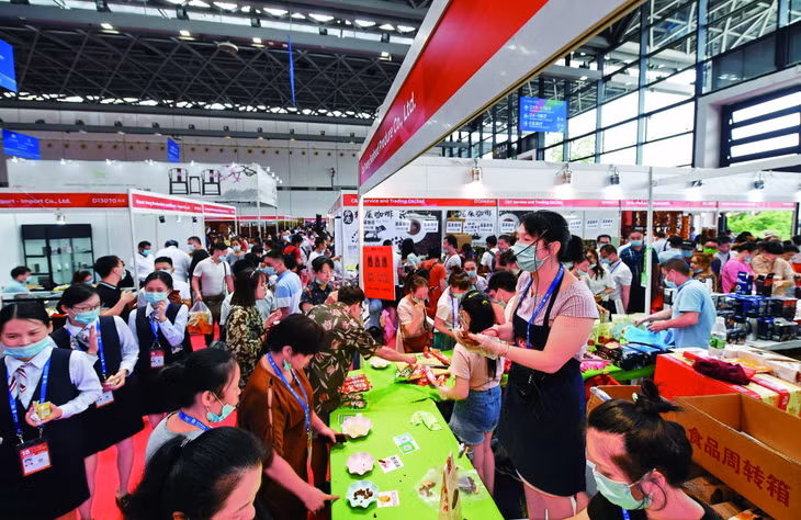 在第18届中国-东盟博览会上，参展商在推介越南食品。 Đại diện doanh nghiệp giới thiệu thực phẩm Việt Nam tại Hội chợ triển lãm Trung Quốc - ASEAN lần thứ 18.