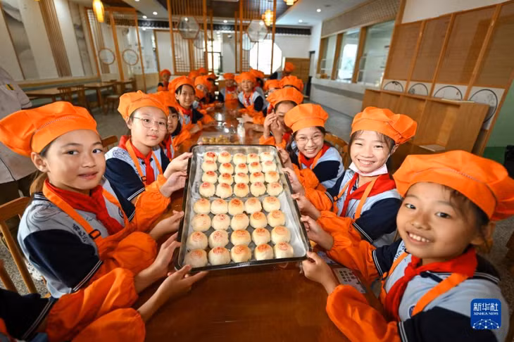 在江苏省昆山开发区震川小学，学生们展示烘焙好的月饼。王须中 摄 Các em học sinh trưng bày bánh Trung thu đã nướng xong tại Trường tiểu học Chấn Xuyên, Khu Phát triển Côn Sơn, tỉnh Giang Tô. Vương Tu Trung chụp